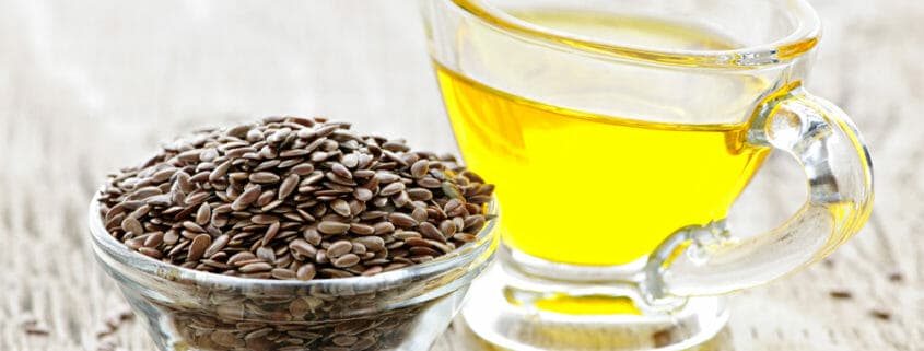 Seeds in a glass bowl and oil in another container, both sources of omega 3 fatty acids for horses