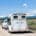 A horse inside of a horse trailer being pulled by a truck down a rural road