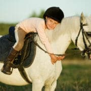 shutterstock_205878118 A small child on a grey pony, hugging her beloved pony club mount that is fed a balanced diet