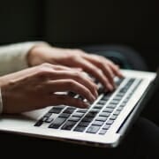 Woman entering diet information into FeedXL Woman's hands on laptop keyboard