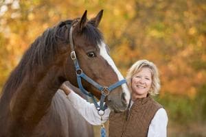 Blond Woman Standing Next To Brown Horse